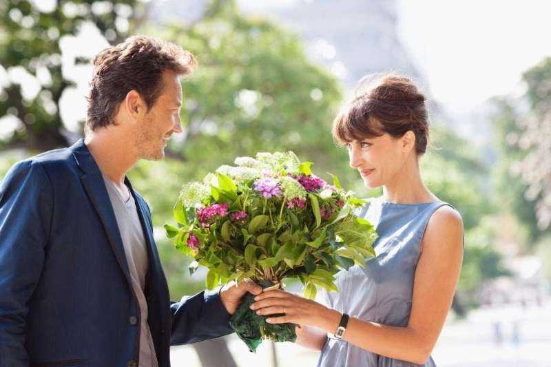 Мужчина дарит цветы женщине